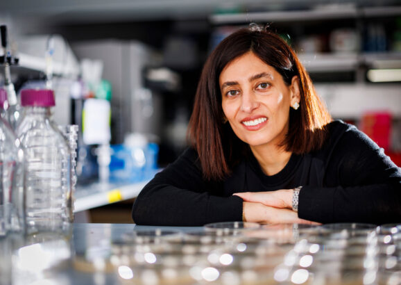 Nikta Fakhri in the lab, with petri dishes in foreground.