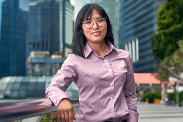 woman poses in front of city background