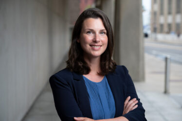 Woman smiles and poses with arms crossed