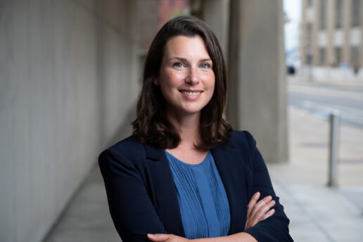 Woman smiles and poses with arms crossed
